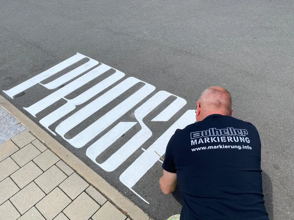Asphaltkalligraphie / Werbemarkierung